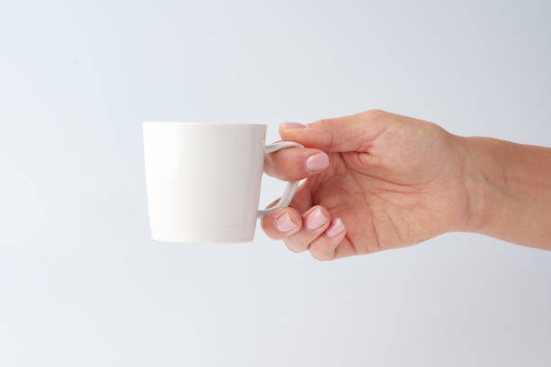 istock Female hand holding coffee mug against white background 1959225999