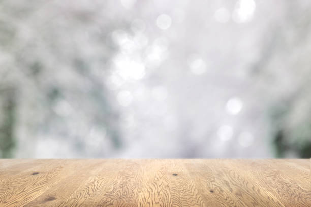 istock Blurred background seen through a wooden table with wood grain, background with depth, snowy background image 1959239637