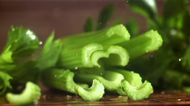 The knife cuts through the fresh sprinkled celery. Filmed on a high-speed camera at 1000 fps.