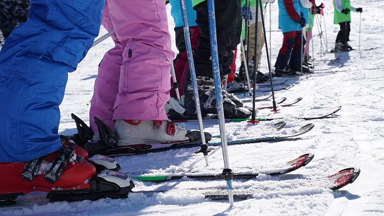 young family skiing doing the first ski lessons for the kids on carving skis