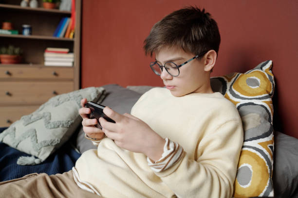 istock Youthful boy playing video game 1959255253