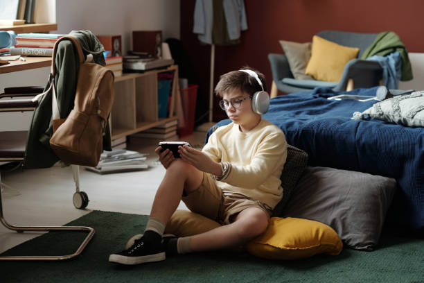 istock Child playing video game in bedroom 1959256283