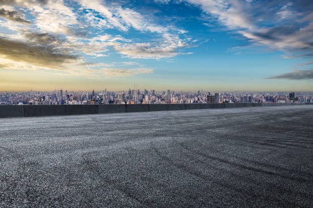 istock Empty asphalt road and mountains with city skyline background 1959271384
