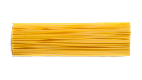 Raw spaghetti pasta isolated on white background. Long pasta top view.