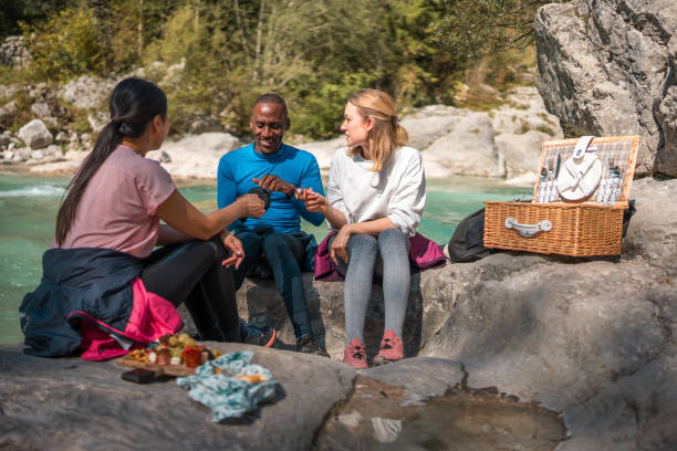 istock Diverse Friends Enjoying Picnic by River During Hike 1959294960