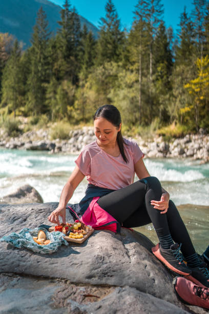 istock Female Hiker Enjoying Picnic by River 1959294961