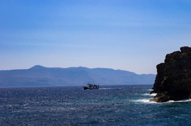 A ship sails on a sea with steep banks, landscape
