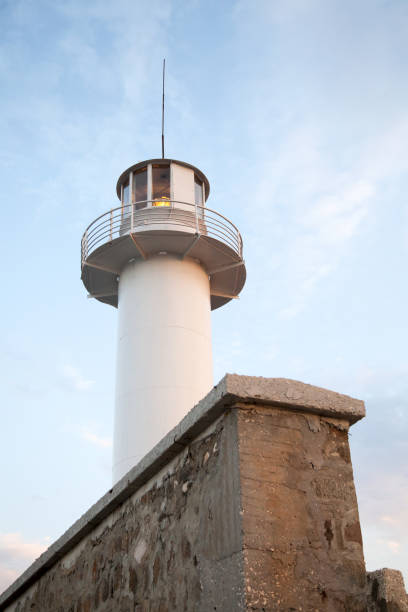 istock White lighthouse tower and stone wall are under blue sky on a daytime 1959321947