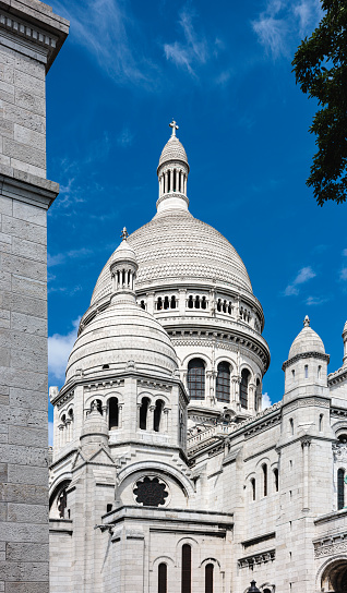 Basilique du Sacre Coeur on Montmartre in Paris, France, cloudy blue sky above