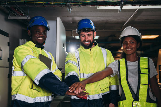 Team engineers and foreman stack hand and shake hands to show success at inverter solar panel room. Worker industry join hand for collaboration.
