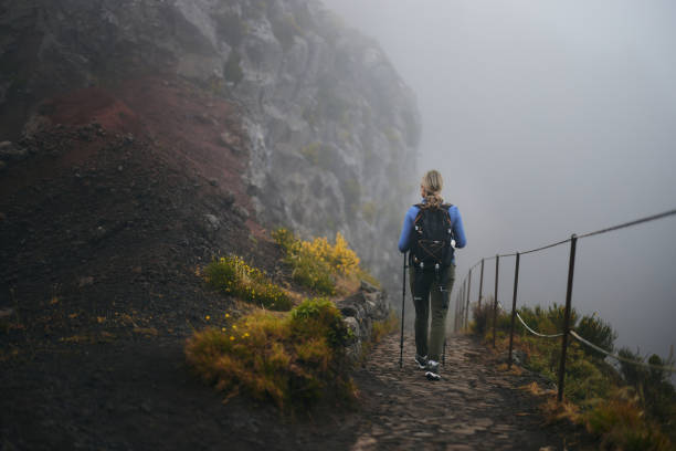 istock Back view of a female hiker walking on a path at mountain. 1959353868