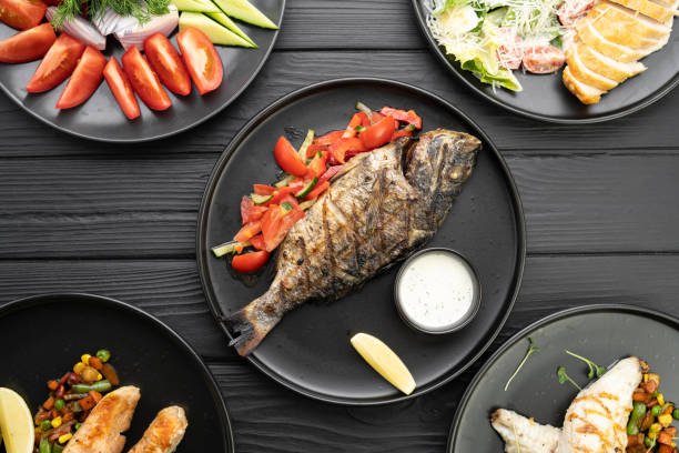 Flat lay of various grill and bbq fish with vegetables on vintage table. Sauces and ingredients for grilling