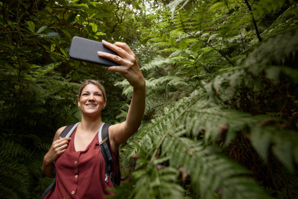 istock Happy female backpacker taking a selfie among greenery in the forest. 1959357639
