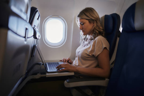 istock Young woman using laptop in a plane. 1959367102