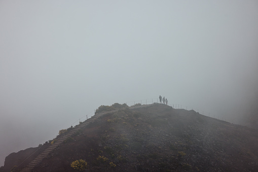 View of the mountain during foggy day with group of hikers. Copy space.