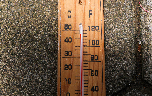 Celsius and fahrenheit scale thermometer shows plus 30 degrees during midday in Asia. The thermometer shows temperatures above 40 degrees in summer