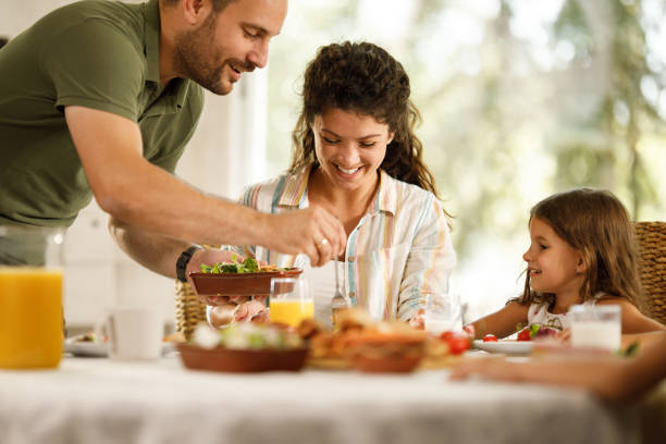 istock Happy parents and their small kid enjoying during breakfast in dining room. 1959389794