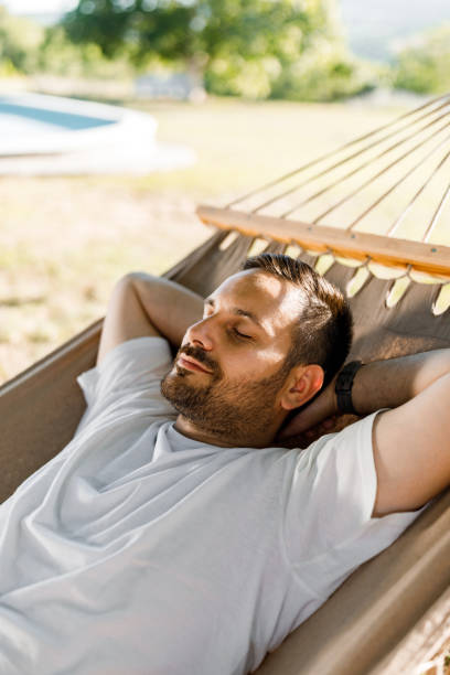 istock Mid adult man sleeping in hammock at the backyard. 1959391870