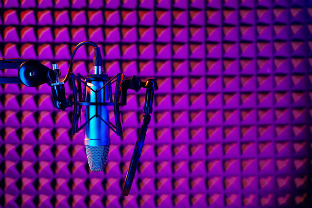 istock Professional studio microphone against acoustic foam panel background in neon light 1959404484