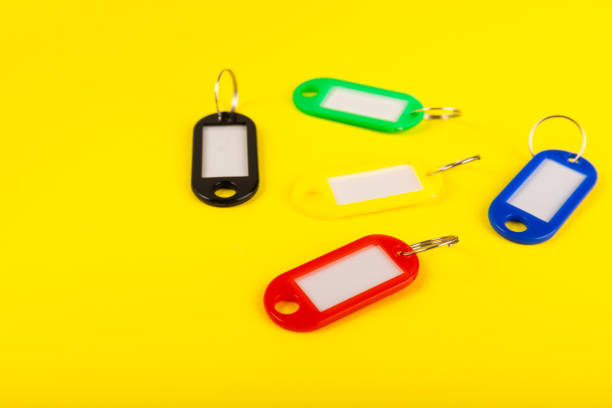 Plastic key ring in different colors with a place for a signature on a bright colored background. Bunch of keys with keychain. Mock-up keychain.Copy space.Concept for renting and selling real estate.