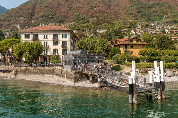 the pier of the village lenno with tourists are waiting for the ferry boat for sightseeing on lake como. - lenno foto e immagini stock