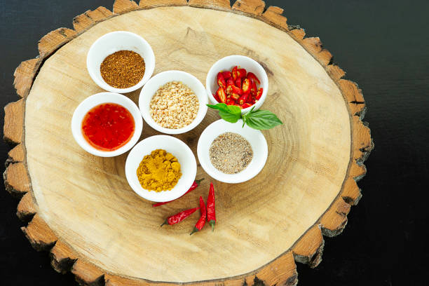 Above view of assortment of spices bowl on round cutting board