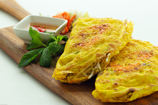 Vietnamese Crepe is thin, crispy filled with shrimp and pork and vegetable and served with fresh herbs and refreshing lime dipping fish sauce.