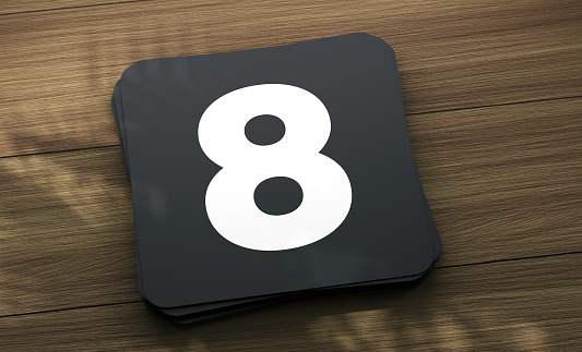 Placard with the number 8 on the wooden table. Finance Concept.