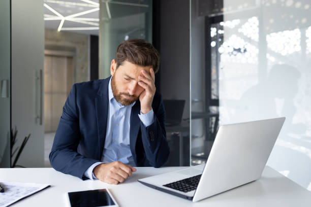 istock Stressed businessman with headache working late on laptop in modern office, overworked employee concept 1959525090