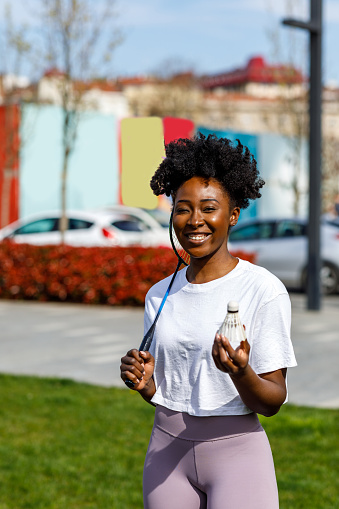 Young Female Athlete of African Ethnicity is Holding a Badminton Racket and Preparing the First Shot.