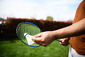 Close-Up View of an African Man Holding a Badminton Racket and Badminton Shuttlecock.