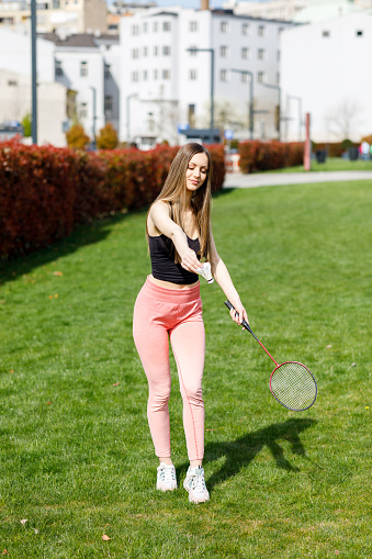 Young Woman in Nature is Playing a Badminton and Preparing for Serve.