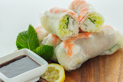 Vietnamese shrimp/pork with vermicelli salad roll with hoisin dipping sauce on wooden cutting board
