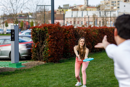 Young Woman is Enjoying in Summer Day and Trying to Catch a Frisbee.