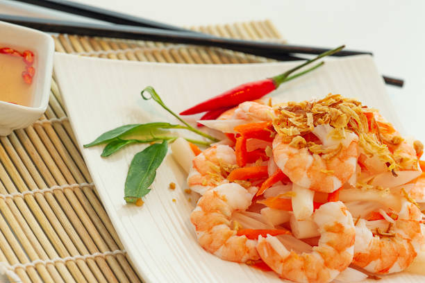Thai papaya salad with fish sauce dipping on bamboo plate