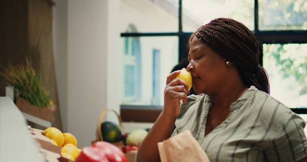 istock Customer smelling fresh ripe lemons from local garden, 1959544414