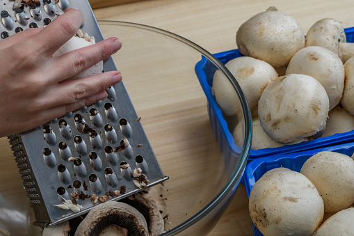 Fresh mushrooms grated on a metal grater