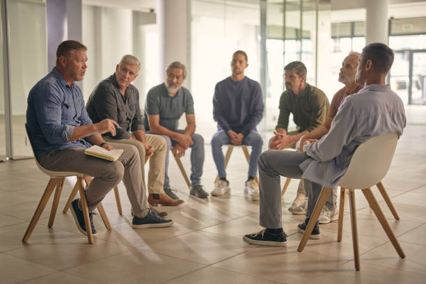 istock Therapy for men, community and support with discussion, communication and prayer circle in bible study. Meeting, mental health and faith with diversity, conversation for counseling and rehabilitation 1959565619