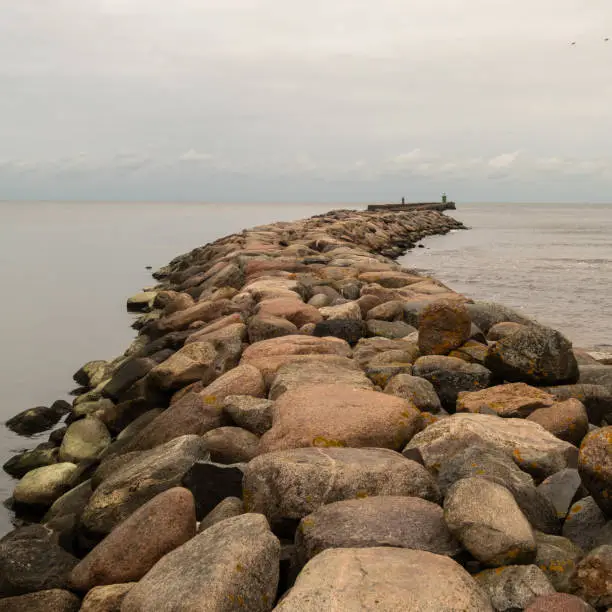 On the stone jetty, a journey unfolds, guiding to the beacon overlooking the sea's expanse, a tranquil haven amidst boundless waves.