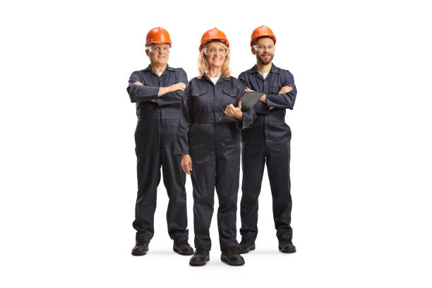 istock Team of factory workers in uniforms and helmets 1959602825