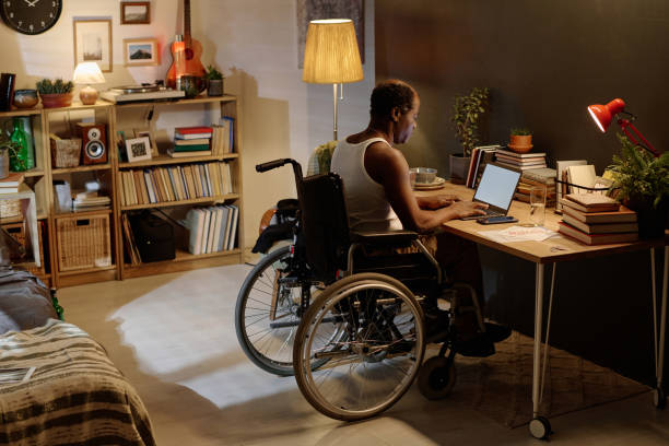 istock Mature Black Man with Disability Typing on Laptop at Home 1959606138