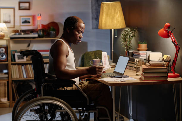 istock African American Man with Disability Doing Paperwork at Home 1959606678