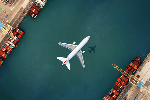 Airplane flying over container port