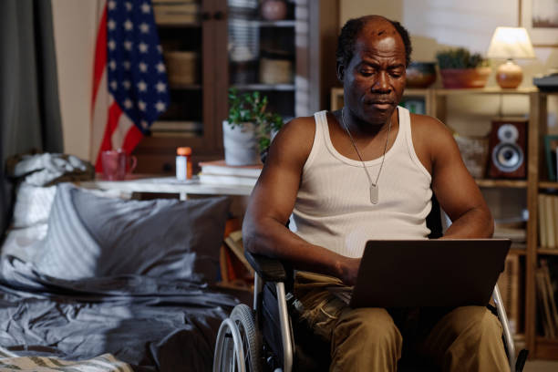 istock Senior Black Man in Wheelchair Working Remotely on His Portable Computer 1959607744