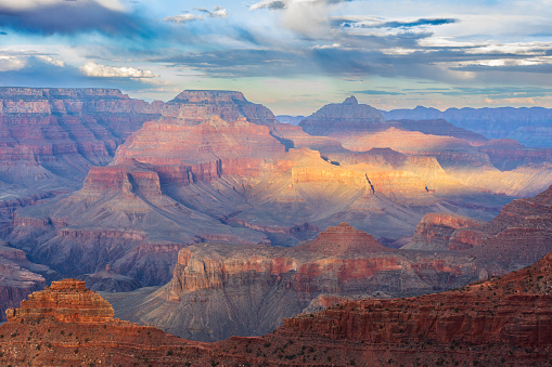 The last ray of sun broke through the clouds at sunset and illuminated the majestic Grand Canyon.