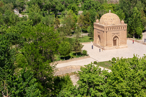 Samani Ismail or Samanid mausoleum in Bukhara. Top view in the park with green trees around. Public park, Bukhara (Buxoro), Uzbekistan
