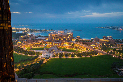 Abu Dhabi, United Arab Emirates - April 14, 2023: Emirates palace in Abu Dhabi top landmark skyline view with the city downtown in the United Arab Emirates capital city. Elevate your perspective with this breathtaking top view of the iconic Emirates Palace in Abu Dhabi, UAE. The opulent architecture of the palace is set against the backdrop of the vibrant city downtown, creating a stunning contrast that defines the capital's grandeur.