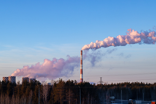 Smoking pipes and cooling towers of a thermal power plant against a blue sky