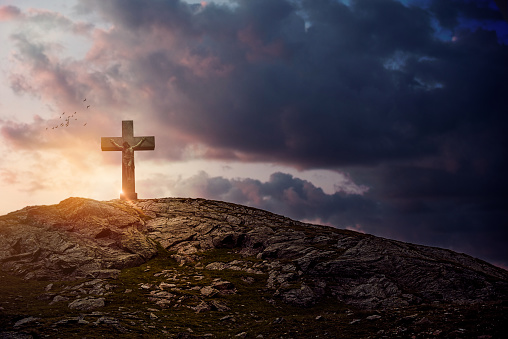 Metal crucifix over beautiful sky. Easter concept.