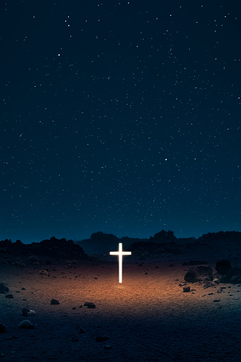 Light cross in desert at night. Easter concept.